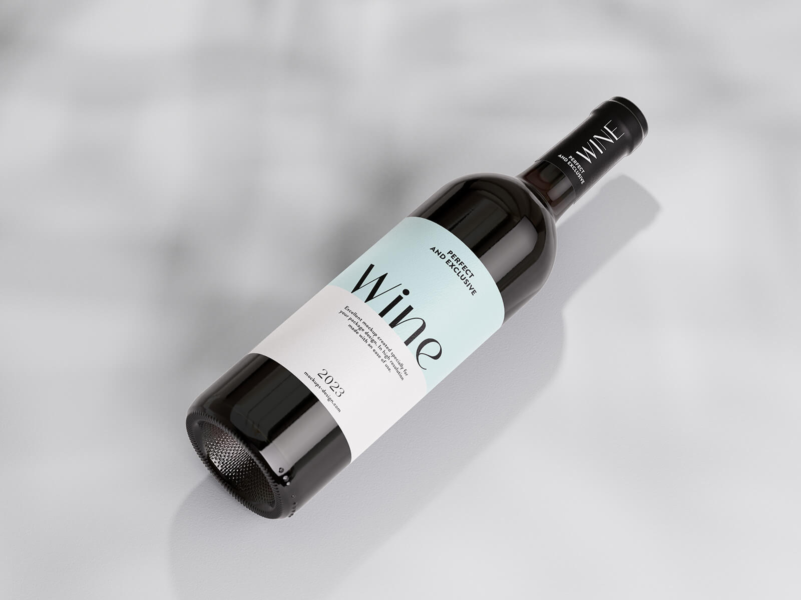 Dark wine bottle mockup labelled Wine, Perfect and Exclusive, lying on its side on a light marbled surface with dappled shadow.