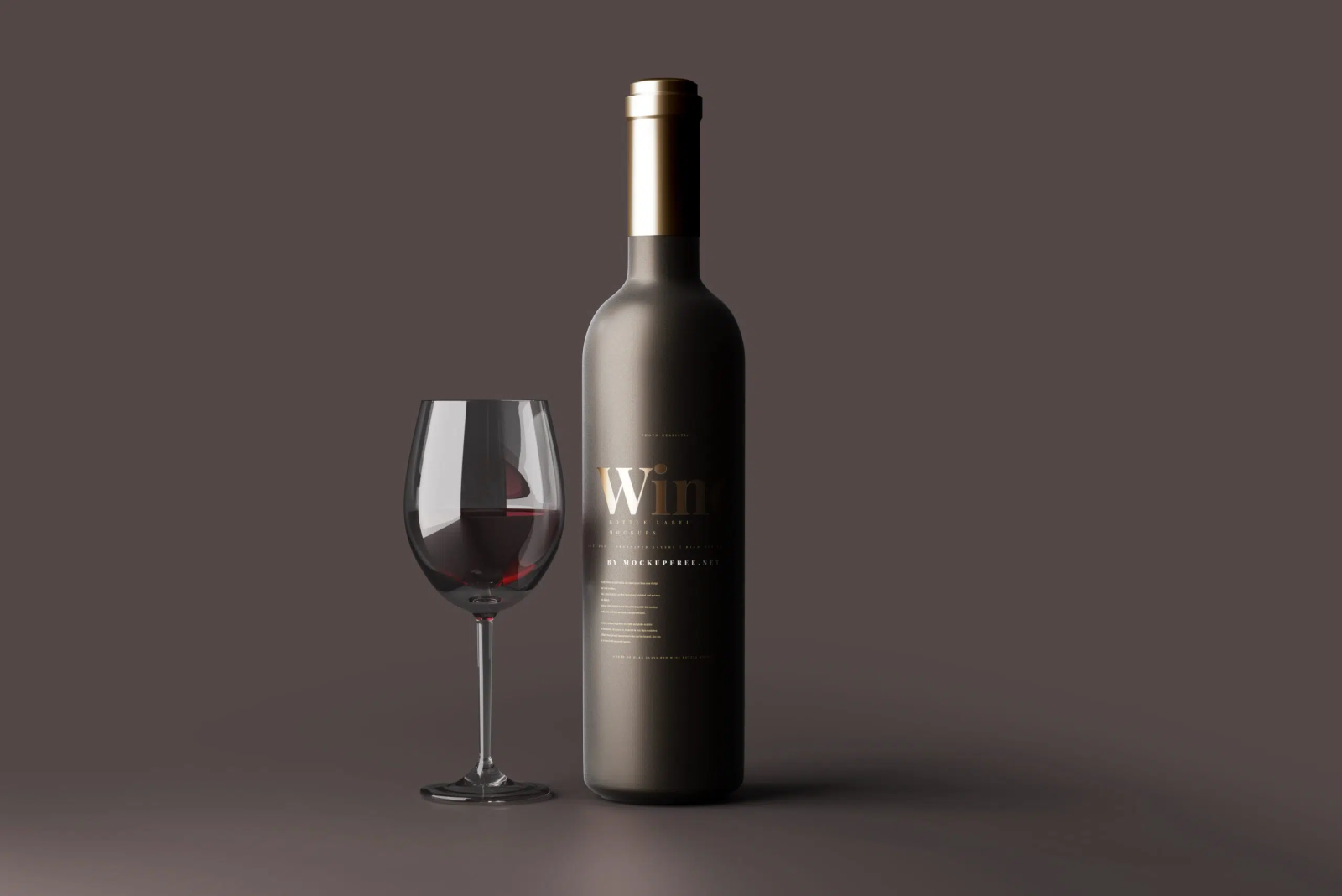 Matte dark wine bottle with gold cap and gold foil Wine label, beside a glass of red wine, on a plain brown background.
