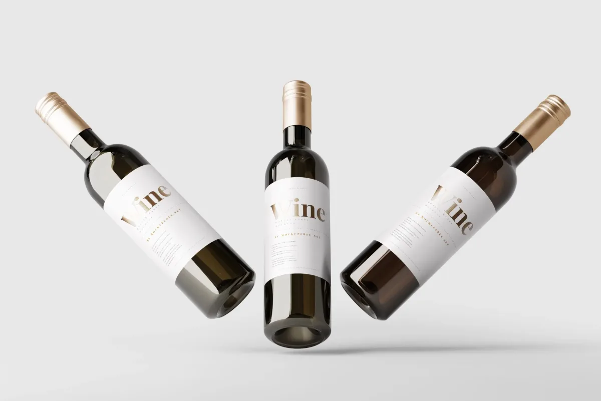 Dark green wine bottle PSD mockup shown from three angles, with gold foil caps and a cream label reading Wine, against a plain grey background.