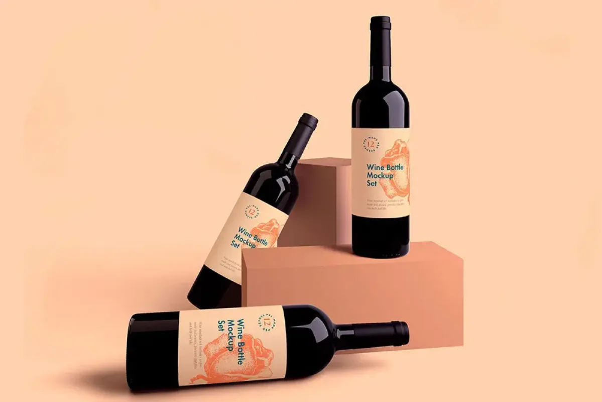 Three wine bottles with matching Wine Bottle Mockup Set labels featuring an illustrated bird design, arranged upright, tilted and lying on pastel plinths.